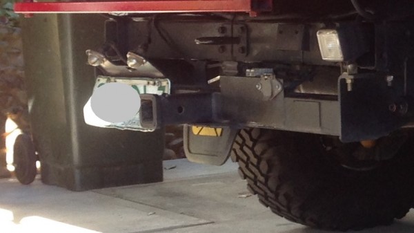 Number plate all bent up and hanging below the tow bar